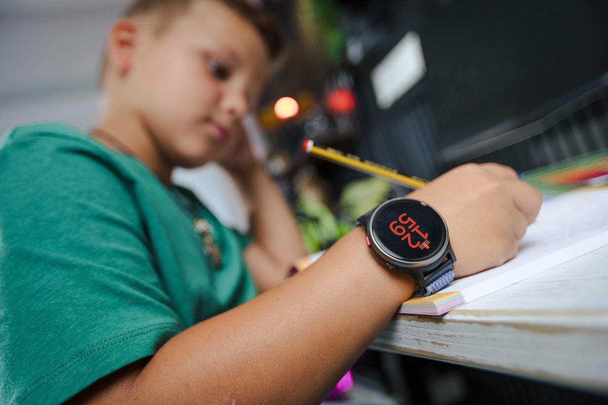 Kind trägt seine Anio Uhr im Unterricht